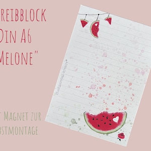 Könnte beinhalten: Ein liniertes Notizblock mit Wassermelonen-Motiv. Der Notizblock hat einen weißen Hintergrund mit rosa Aquarellspritzern und Wassermelonen-Illustrationen. Der Text "SCHREIBBLOCK DIN A6 'MELONE'" ist rot geschrieben. Er hat einen Magneten zur Selbstmontage.