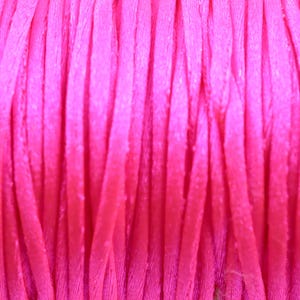 May include: Close-up of a spool of bright pink embroidery floss.
