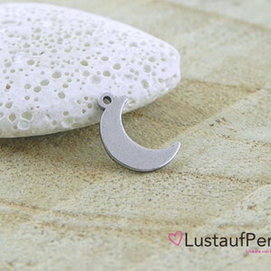 May include: A silver crescent moon charm with a loop for attaching to a necklace or bracelet.