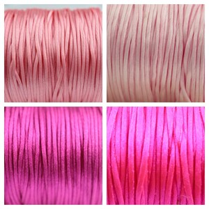 May include: Close-up of four spools of waxed cord in pink and fuchsia shades. The cord is smooth and shiny, perfect for crafting and jewelry making.
