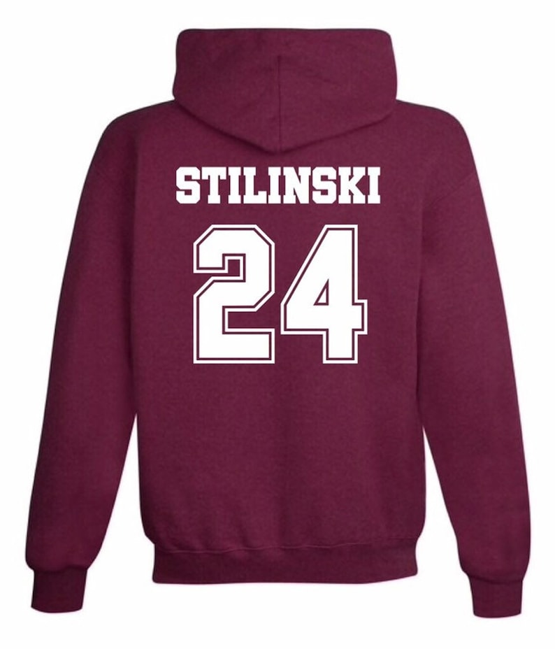 May include: Burgundy hooded sweatshirt with white text that reads "STILINSKI 24" on the back.