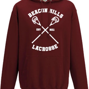 May include: Burgundy hooded sweatshirt with a white graphic of crossed lacrosse sticks and the text "Beacon Hills Lacrosse Est 2011".