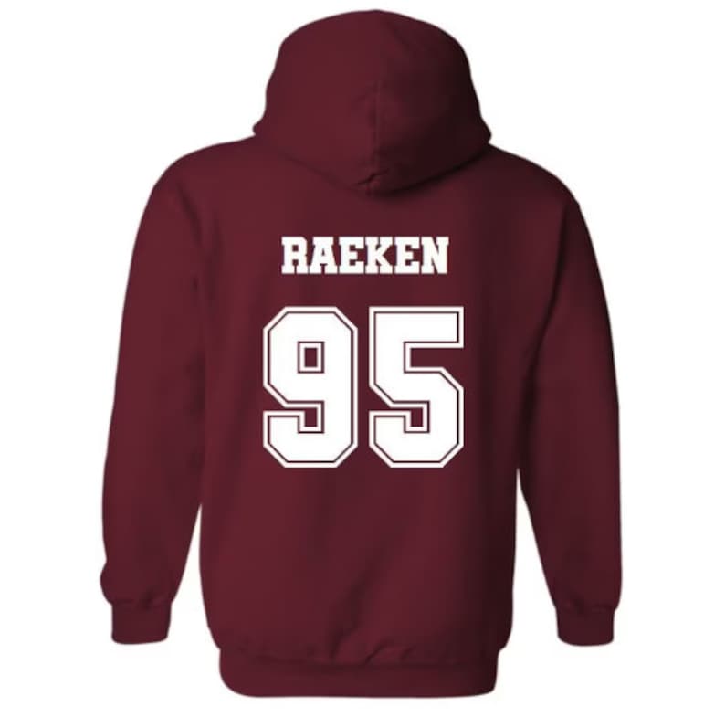 Pode incluir: Camisola de capuz cor vinho com o nome "Raeken" e o n&uacute;mero "95" impressos em branco nas costas.