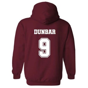 May include: Burgundy hooded sweatshirt with white text that reads "DUNBAR 9" on the back.