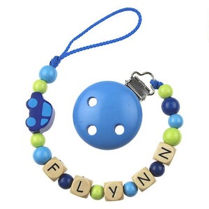 Puede incluir: Un mordedor de bebé de madera azul y verde con un amuleto de coche azul y el nombre "FLYNN" escrito en bloques de madera. El mordedor tiene un clip de madera azul.