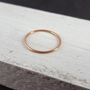 Könnte beinhalten: Ein schlichter, dünner Ring aus Roségold.