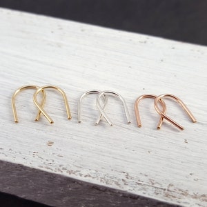 Pu&ograve; includere: Tre paia di piccoli orecchini a cerchio in oro, argento e oro rosa. I cerchi sono semplici e delicati, con una forma leggermente curva.