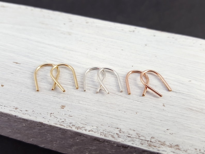Pu&ograve; includere: Tre paia di piccoli orecchini a cerchio in oro, argento e oro rosa. I cerchi sono semplici e delicati, con una forma leggermente curva.
