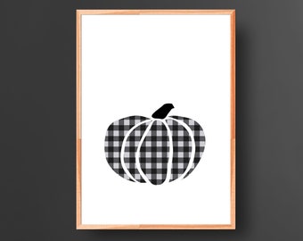 Puede incluir: Una silueta de calabaza a cuadros en blanco y negro sobre un fondo blanco. La calabaza está enmarcada en un marco de madera claro.