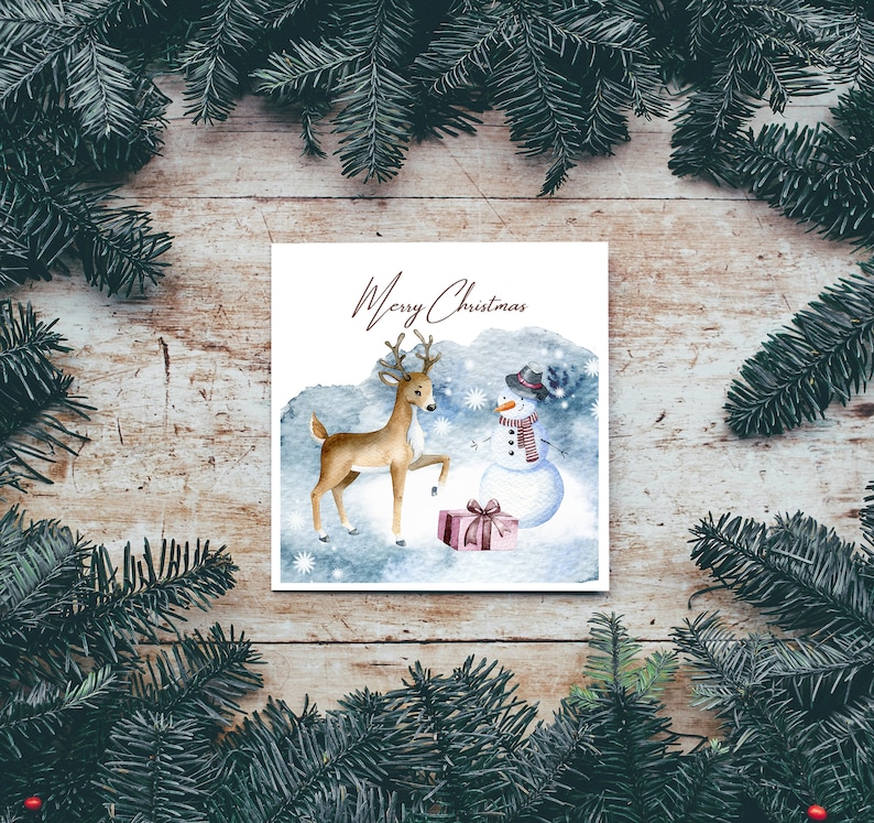 May include: A watercolor Christmas card featuring a deer and a snowman with a red and white striped scarf. The card has a blue background with white snowflakes and the text "Merry Christmas".