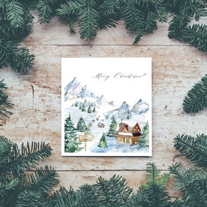 May include: A watercolour Christmas card depicting a snowy mountain scene with a small cabin, trees, and a sign that reads "North Pole". The card features the text "Merry Christmas!" written in cursive.