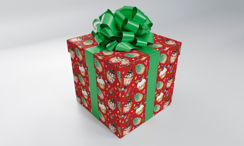 May include: A large, square gift box wrapped in red paper with a repeating pattern of cupcakes, ice cream cones, and other sweets. The box is tied with a wide green ribbon and a large, fluffy green bow on top.