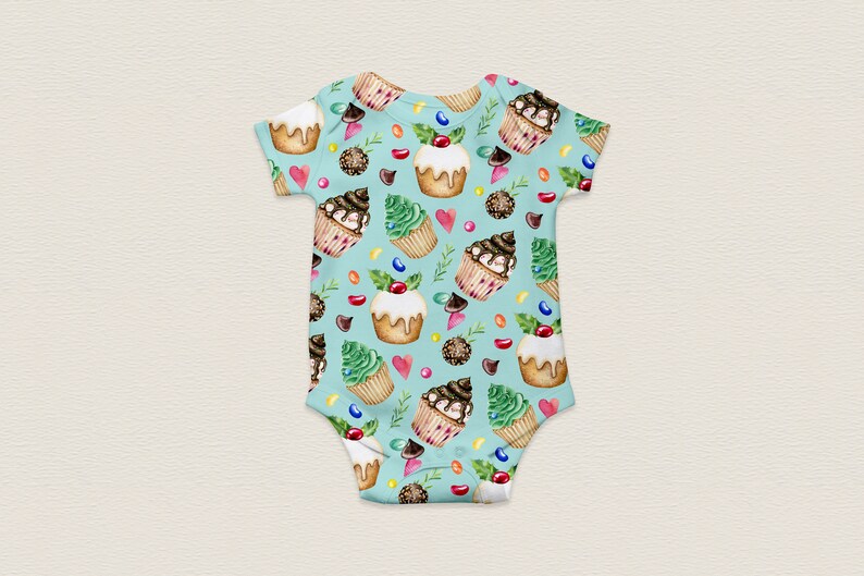 May include: A light blue baby onesie with a pattern of cupcakes, candy, and green leaves. The cupcakes are decorated with chocolate frosting, sprinkles, and cherries.