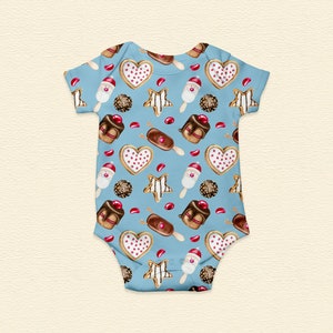 May include: A light blue baby onesie with a repeating pattern of illustrated sweets. The pattern includes heart-shaped cookies, star-shaped cookies, chocolate-covered ice cream bars, and chocolate candies. The onesie is made of soft fabric.