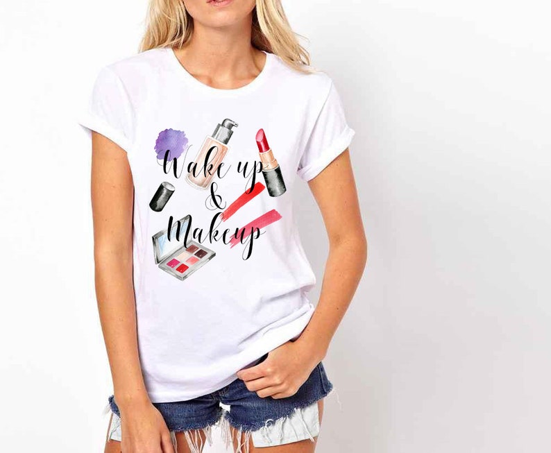 May include: White t-shirt with the text "Wake up & Makeup" in black lettering. The design features a watercolour illustration of makeup products, including lipstick, foundation, and eyeshadow.