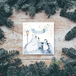 May include: A white card with a watercolor illustration of a polar bear and a penguin holding ice cream cones. The card has a blue banner with the text "Merry Christmas" and a gold glitter background.