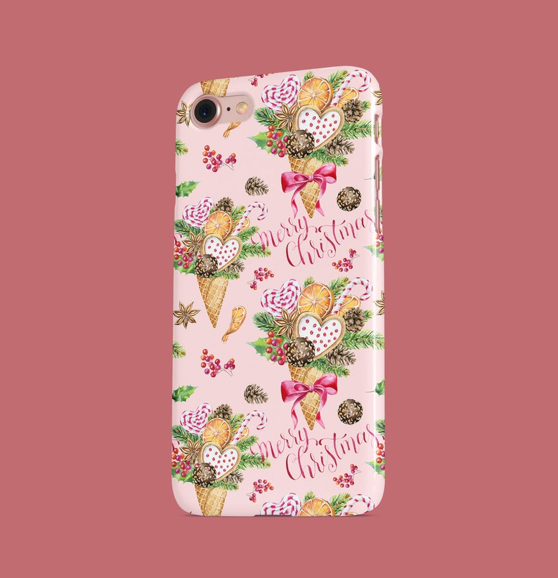 May include: A pink phone case featuring a repeating pattern of Christmas-themed ice cream cones. Each cone is decorated with cookies, candy, and berries, with a red bow. The words "Merry Christmas" are written in cursive.