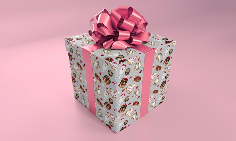 May include: A square gift box wrapped in gray paper with a pink bow. The paper is decorated with a pattern of various pastries, including donuts, cakes, and cookies.