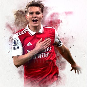 May include: A watercolor-style illustration of a soccer player wearing a red and white soccer jersey with the Adidas logo and the text "Fly Better". The player is celebrating a goal with his hand on his chest.