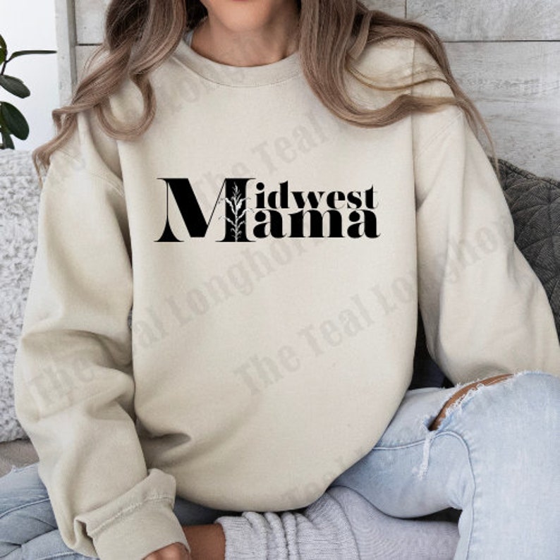 May include: A beige sweatshirt with the text "Midwest Mama" in black lettering with a stylized plant graphic.