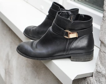 Botines vintage de piel negra Buffalo London con detalle de hebilla, talla 40, estilo minimalista.