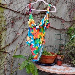 Può includere: Una tazza di ceramica bianca con un manico nero e la scritta "But First, Coffee" in nero, con un carattere a mano. La tazza è su una superficie bianca.