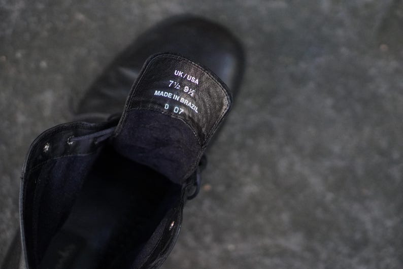 Op de afbeelding: Zwarte leren laars met het binnenlabel zichtbaar. Het label luidt "UK/USA 7 1/2 9 1/2 MADE IN BRAZIL D 07". De laars is geregen en lijkt nieuw.