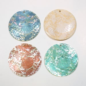 May include: Four round, iridescent, mother-of-pearl shell pendants with a variety of sea-life designs in blue, green, and orange.