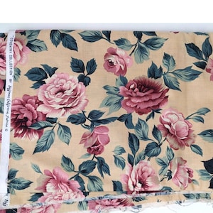 May include: Beige fabric with a floral print featuring pink and burgundy roses with green leaves. The fabric is labeled "Coventry Collection by Hoffman California Fabrics".