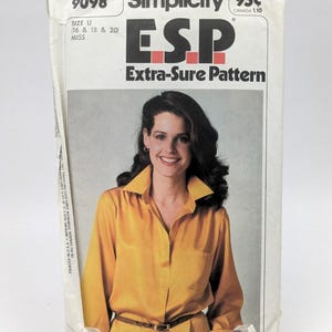 May include: Simplicity sewing pattern number 9098, an Extra-Sure Pattern (ESP) for a blouse, size U (16, 18, and 20) for misses. The pattern shows a woman wearing a yellow blouse with a collar and a brown belt.