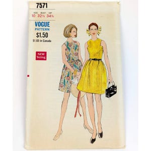 Puede incluir: Sobre de patrón Vogue vintage con ilustraciones de dos vestidos. Uno es amarillo con cinturón negro, el otro floral. El sobre incluye el número de patrón, la talla y "Vogue Pattern".