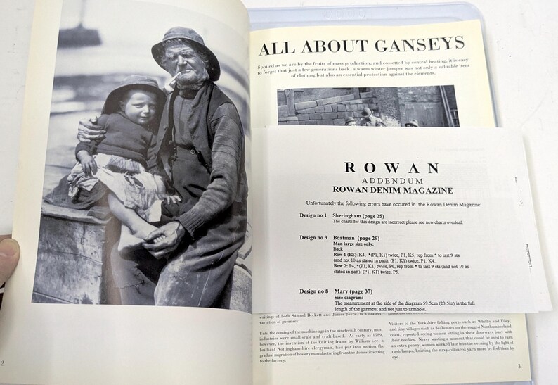 Puede incluir: Fotograf&iacute;a en blanco y negro de una persona mayor y un ni&ntilde;o, ambos con sombreros, sentados juntos. La imagen es de un libro, con texto visible en las p&aacute;ginas, incluyendo "ALL ABOUT GANSEYS" y "ROWAN DENIM MAGAZINE".
