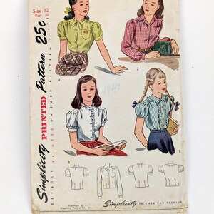 May include: A vintage Simplicity sewing pattern with illustrations of blouses. The cover displays four blouse designs, with a size 12 and bust 30 measurement. The text includes "Simplicity" and "America's Fashion."
