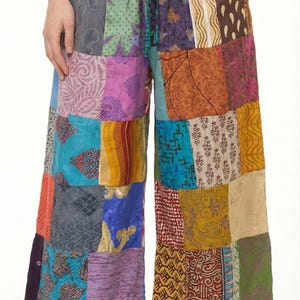 Può includere: Pantaloni palazzo patchwork multicolore con coulisse in vita. I pantaloni a gamba larga sono realizzati con un patchwork di tessuti diversi nei toni del blu, viola, arancione e giallo. Misurano circa 100 cm di lunghezza.