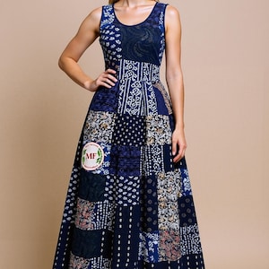 Puede incluir: Vestido largo sin mangas de patchwork en tonos azules, con cuello redondo y cintura entallada. El vestido presenta una variedad de cuadrados estampados y un parche con un logotipo. El vestido es largo hasta el suelo.