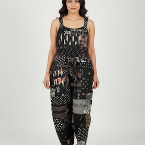 Puede incluir: Mono negro con diseño patchwork. La parte superior presenta un escote cuadrado y tirantes de lunares. Los pantalones tienen un corte holgado y un lazo en la cintura. El patchwork incluye varios patrones y colores.