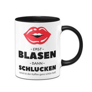 Könnte beinhalten: Weiße Keramik-Kaffeetasse mit schwarzem Rand und Henkel. Die Tasse zeigt einen roten Comic-Mund mit dem Text " - ERST - BLASEN - DANN - SCHLUCKEN sonst ist der Kaffee ganz schön heiß" in Schwarz.