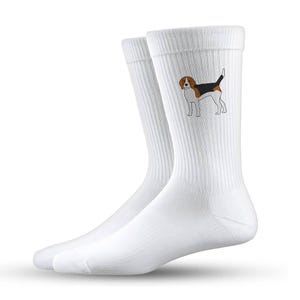 Könnte beinhalten: Ein Paar weiße Crew-Socken mit gerippter Struktur. Jede Socke zeigt eine detaillierte Illustration eines Beagle-Hundes in Schwarz, Braun und Weiß. Die Socken sind für Komfort und den täglichen Gebrauch konzipiert.
