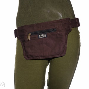 May include: A brown canvas fanny pack with a zippered pocket and a black strap. The fanny pack has a gold zipper and a label that reads "SHIVA Tribal Shop".