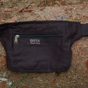 May include: A black canvas fanny pack with a zippered pocket and a silver buckle. The pocket has the text "SHIVA Shaman Shop" printed on it.
