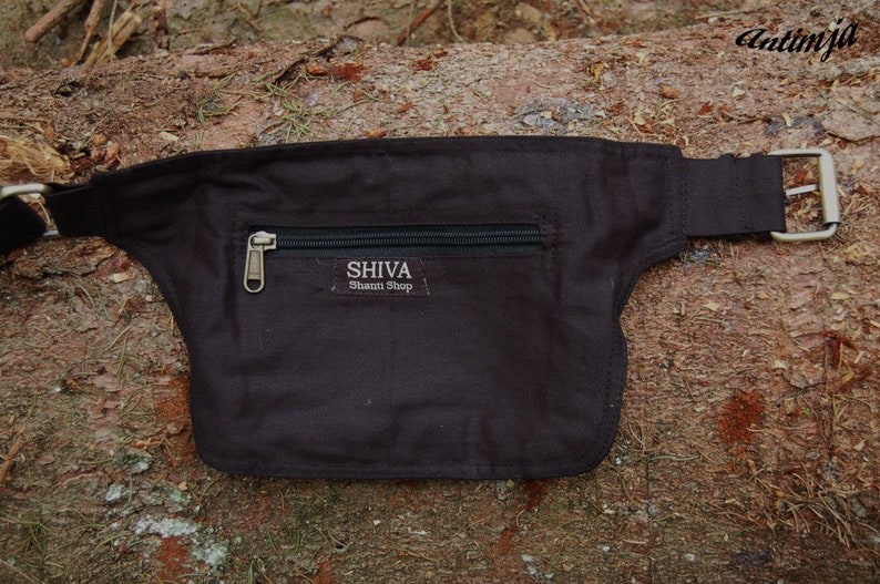 May include: A black canvas fanny pack with a zippered pocket and a silver buckle. The pocket has the text "SHIVA Shaman Shop" printed on it.