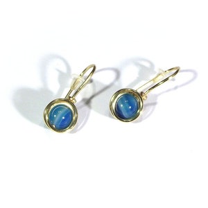 May include: A pair of gold earrings with blue and white agate stones. The earrings are made with a simple wire design.