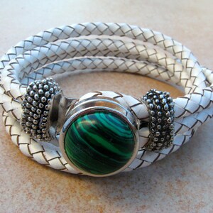 May include: White leather braided bracelet with a green malachite stone and silver accents.