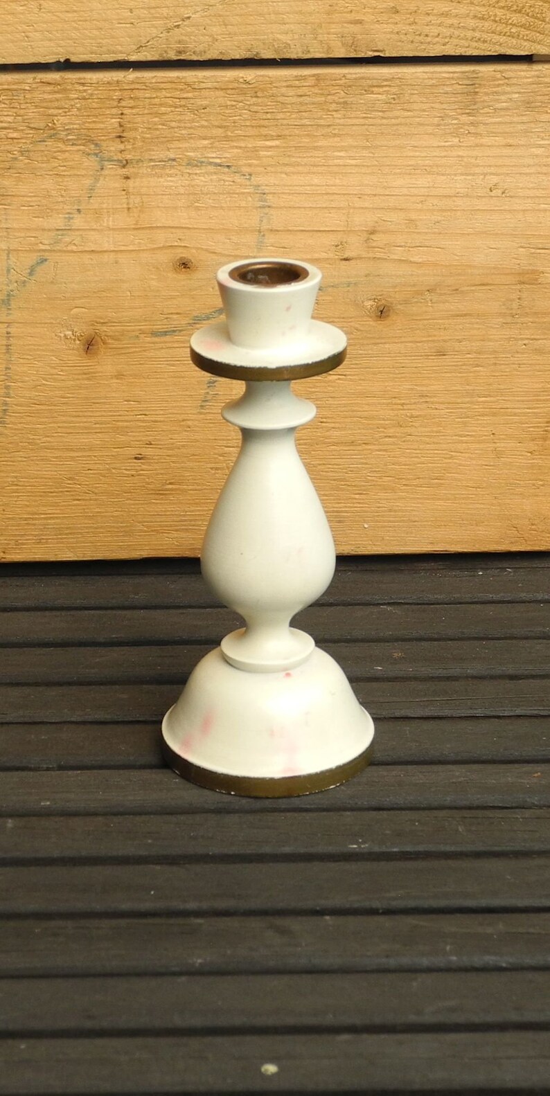 May include: White ceramic candle holder with a gold rim and a simple, elegant design. The holder has a round base and a tall, slender body.