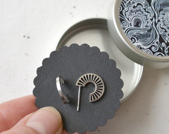 Round, geometrically shaped stainless steel ear studs, including jewelry box