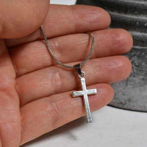Collana con croce cristiana, ciondolo delicato, color argento, senza fronzoli o ornamenti.