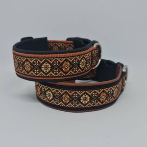 Könnte beinhalten: Zwei schwarze Hundehalsbänder mit orangefarbenem und goldenem Muster. Die Halsbänder sind aus weichem, bequemem Material gefertigt und haben einen sicheren Schnallenverschluss.