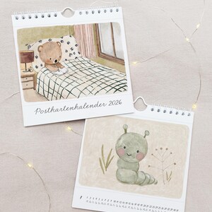 May include: Two spiral-bound calendars with watercolor illustrations. One shows a teddy bear in bed, the other a smiling caterpillar. The text "Postkartenkalender 2026" is on the top calendar. The bottom calendar has a calendar grid.