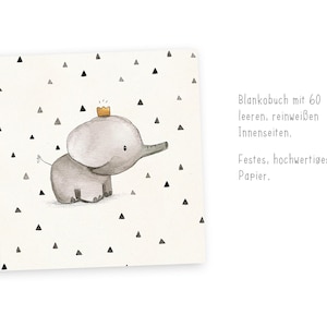 May include: A blank book with a gray elephant wearing a gold crown on the cover. The cover has a white background with black triangle shapes. The text on the cover reads "Blankobuch mit 60 leeren, reinwei&szlig;en Innenseiten. Festes, hochwertiges Papier."