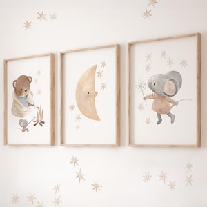 May include: Three framed wall art prints featuring watercolor illustrations. The left print shows a brown bear and a small gray mouse by a campfire. The center print depicts a crescent moon. The right print shows a gray mouse holding a sparkler.